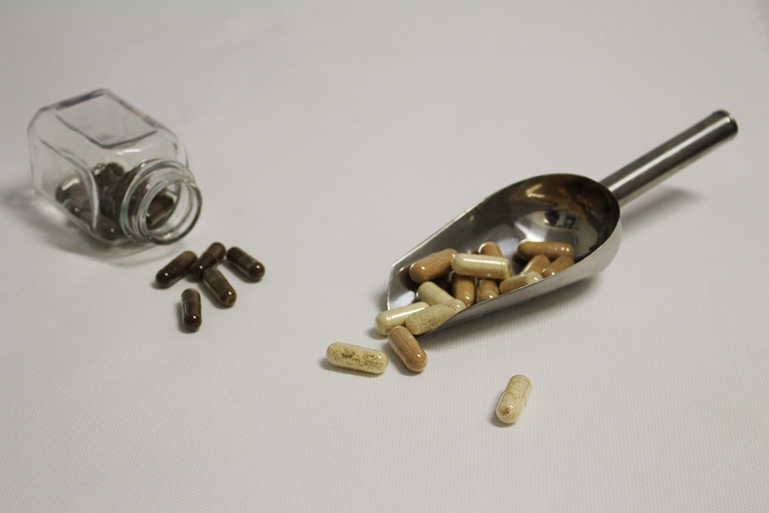 Capsules met schepje en glazen potje